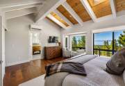Primary Bedroom featuring vaulted ceilings and lake views