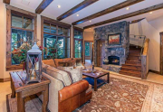 Spacious Family Room featuring a stone fireplace and access to hot tub deck | Northstar Luxury Home