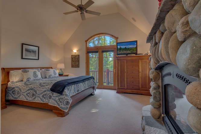 Breathtaking Master bedroom with rock fireplace