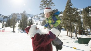 Image of Santa with little girls playing in the snow at Holidays at Squaw Valley | Alpine Meadows for How to Spend the Holidays in North Lake Tahoe blog post