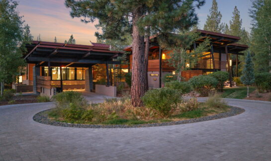 Contemporary luxury home at 9612 Dunsmuir Way in Martis Camp, Truckee, photographed at dusk among pine trees